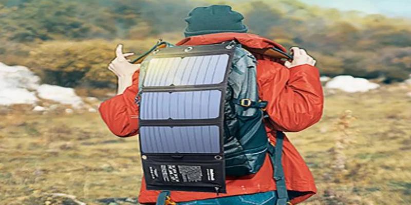 Folding solar charger positioned beside a hiking backpack